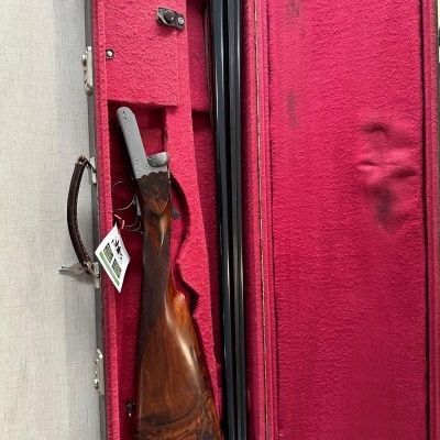 Espingarda desmontada em estojo rígido com forro vermelho