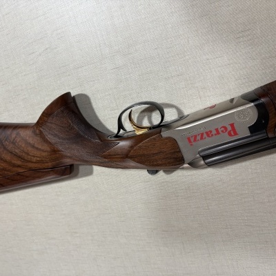Rifle de cano duplo Perazzi com coronha em madeira castanha e gatilho dourado