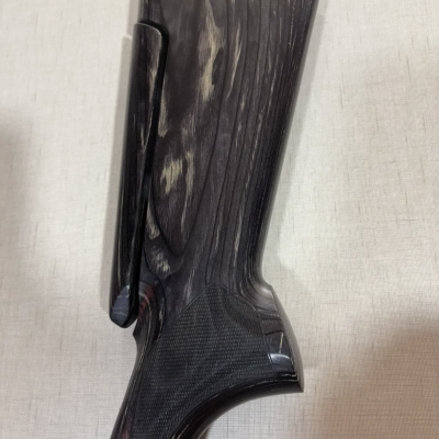 Coronha de madeira escura com textura e acabamento polido sobre fundo neutro.