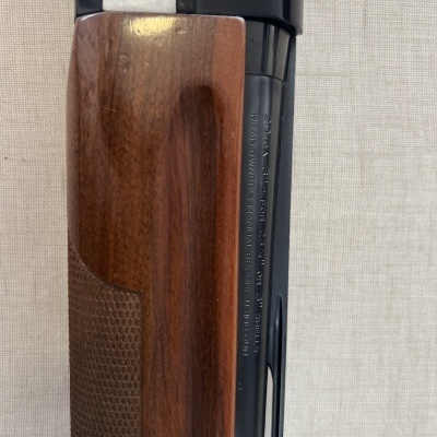 Espingarda com cano metal negro e coronha em madeira escura com gravações