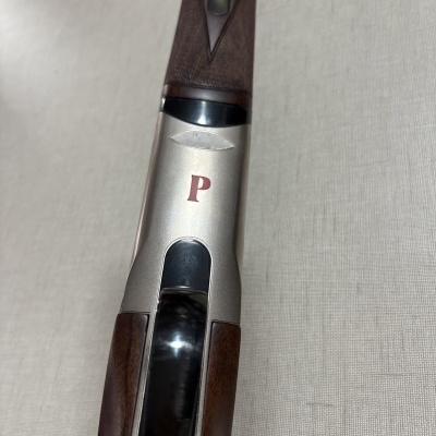 Espingarda metálica e madeira com letra P vermelha