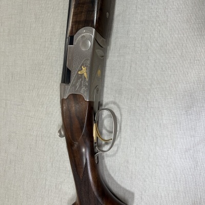 Espingarda de caça com madeira escura e metal prateado gravado