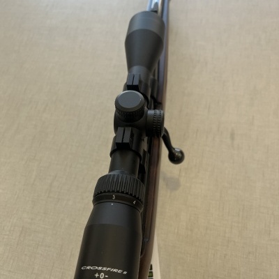 Rifle com coronha em madeira e mira telescópica preta