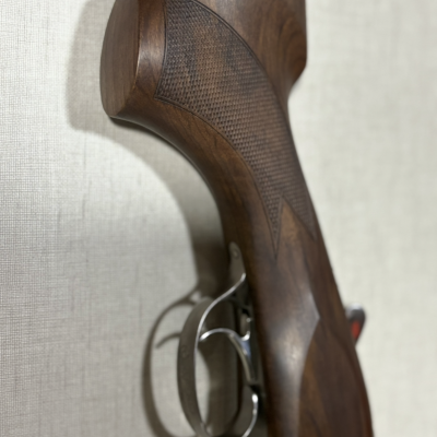 Espingarda com coronha em madeira escura e gatilho metálico