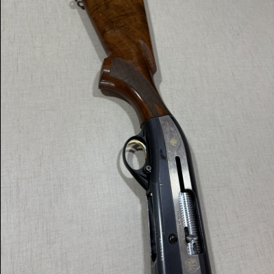 Espingarda com coronha de madeira castanha polida e corpo metálico preto