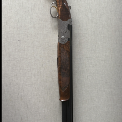 Espingarda de canos duplos com madeira castanha e partes metálicas prateadas com detalhes