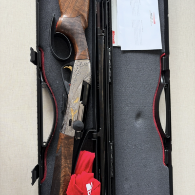 Espingarda de caça com gravuras, dentro de estojo rígido com documentos e tecido vermelho.