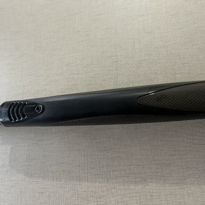 Haste preta de aspirador de pó com botões de ajuste em superfície clara