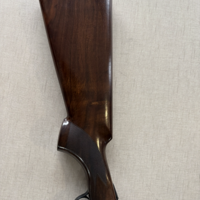 Coronha de espingarda em madeira escura com punho texturizado e ponta de borracha preta