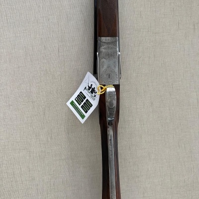 Espingarda de caça com cabo em madeira e partes metálicas prateadas gravadas