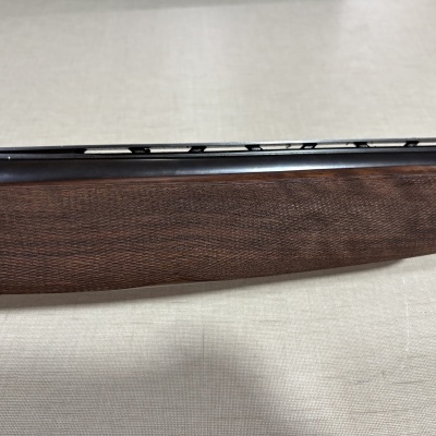 Esteira de madeira e cabo de arma metálico sobre superfície clara