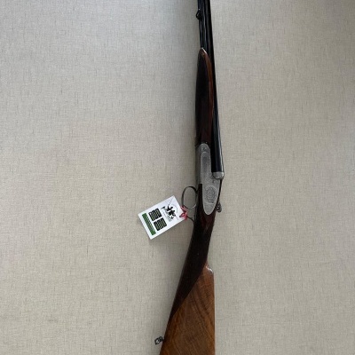 Espingarda de canos paralelos em metal negro e madeira castanha polida