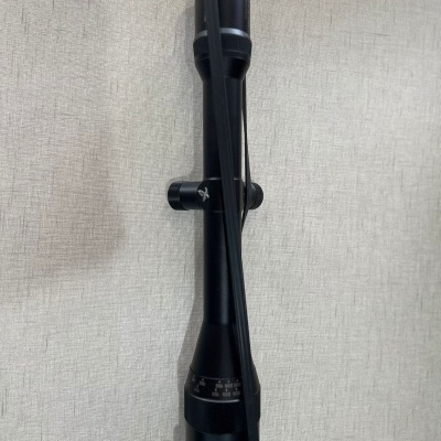 Luneta de mira telescópica preta sobre fundo claro texturizado