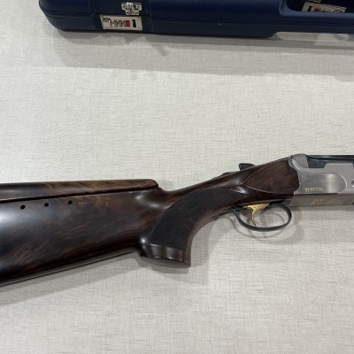 Espingarda de canos sobrepostos com coronha em madeira escura e gatilho dourado