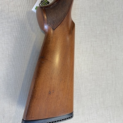 Coronha de espingarda em madeira castanha com textura quadriculada e resguardo preto