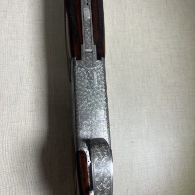 Espingarda com acabamento gravado em metal e cabo de madeira castanha