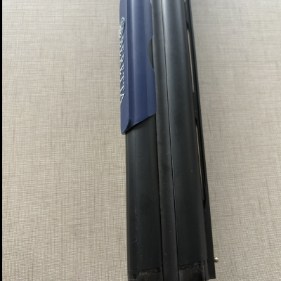 Canos metálicos preto e prateado com protetor azul BERETTA sobre tecido bege