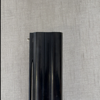 Objeto preto cilíndrico sobre tecido cinza quadriculado