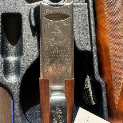 Espingarda com acabamento metálico gravado e punho em madeira num estojo preto