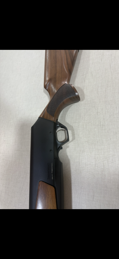 Espingarda com madeira castanha e corpo metálico preto com gravação BROWNING PT 7010882YW311