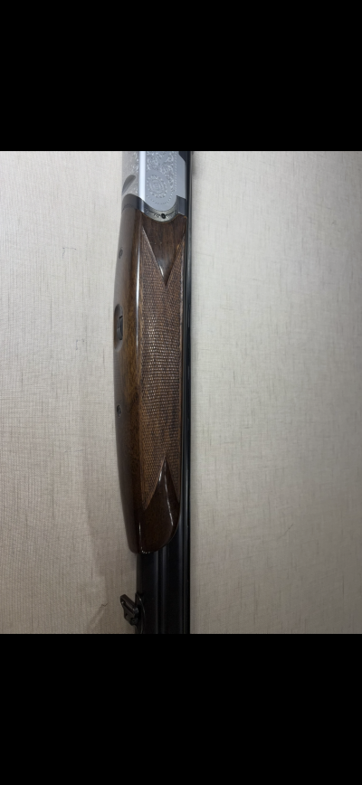 Parte frontal de espingarda com coronha em madeira castanha