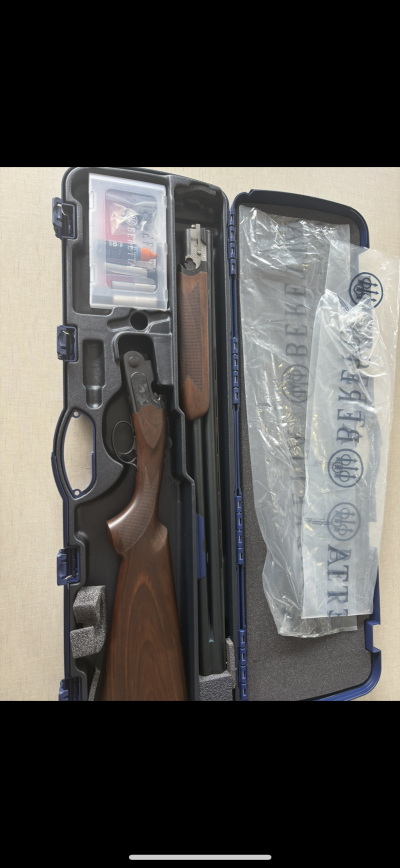 Estojo azul com espingarda desmontada e embalagem de plástico com texto BERETTA