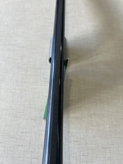 Produto preto com acabamento texturizado sobre superfície cinza claro