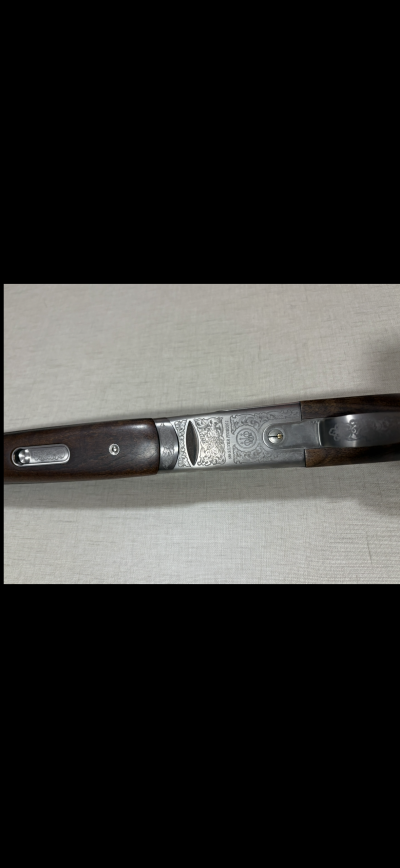 Espingarda com madeira escura e metal gravado