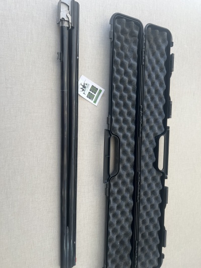 Mala preta rígida com interior em espuma ondulada e dois tubos metálicos pretos ao lado