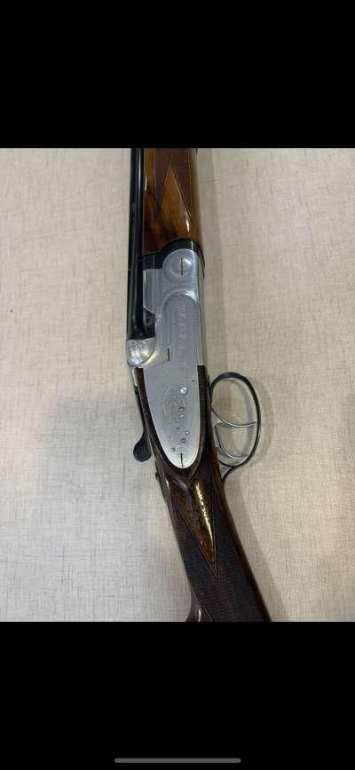 Espingarda de caça com acabamento em madeira polida e metal gravado