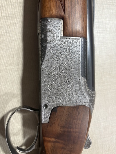 Espingarda com detalhes em madeira e metal gravado