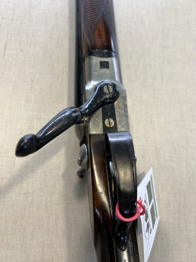 Carabina de madeira e metal com etiqueta pendurada e padrão texturizado na madeira