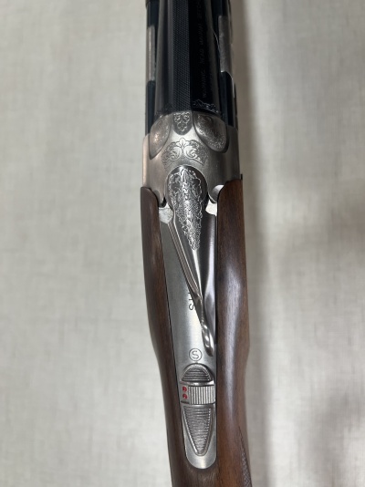 Espingarda sobreposta com coronha em madeira castanha e detalhes metálicos decorativos