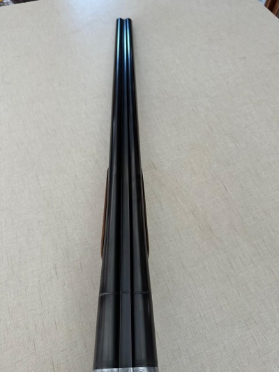 Arma de caça com canos duplos pretos sobre fundo bege