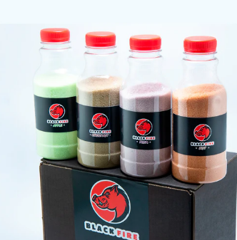 Frascos com pós coloridos e rótulos Black Fire sobre caixa preta