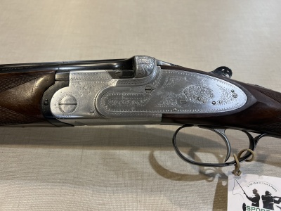 Espingarda com acabamento em metal gravado e coronha em madeira escura