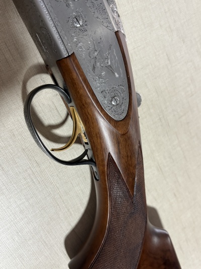 Espingarda de madeira e metal gravado com gatilho dourado e pega texturizada