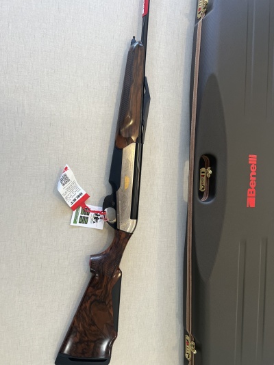 Espingarda Benelli com coronha de madeira e estojo preto ao lado