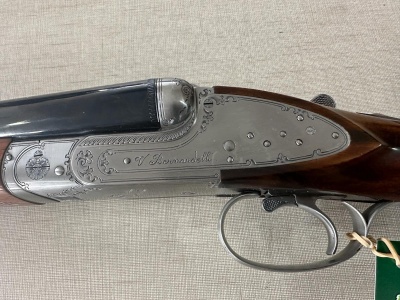 Espingarda de canos duplos com gravações e madeira sobre fundo bege