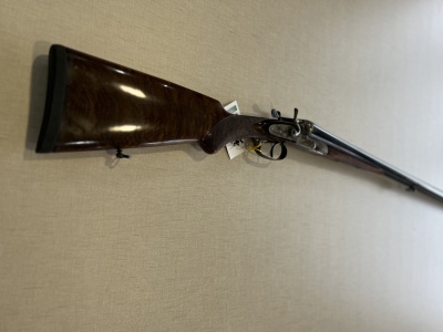 Espingarda de canos duplos com coronha em madeira castanha polida e canos longos em metal preto