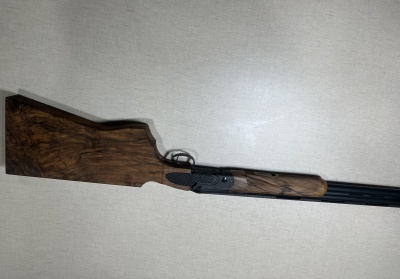 Espingarda de cano duplo com coronha de madeira escura e metal preto