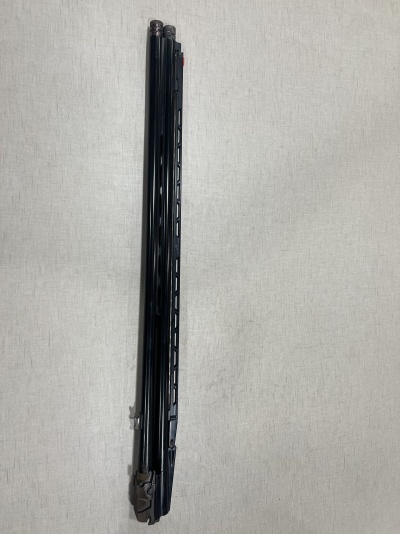 Objeto longo preto com detalhes cinzentos sobre fundo claro texturizado