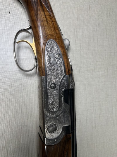 Espingarda de caça com detalhes em madeira e metal gravado