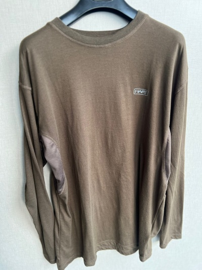 Camisola castanha de manga comprida com etiqueta HART, pendurada num cabide preto.