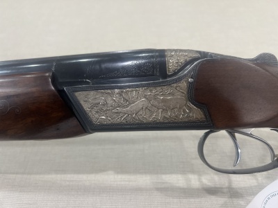 Espingarda de caça com madeira escura e gravação metálica detalhada
