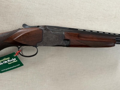 Rifle de caça de cano duplo com acabamentos em madeira e metal cinzento, etiqueta verde Palomucha
