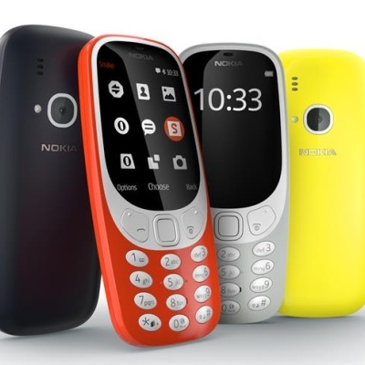 Quatro telemóveis Nokia coloridos com teclado físico em fundo branco