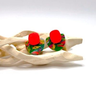 Brincos acrílicos vermelhos e multicoloridos em suporte de madeira