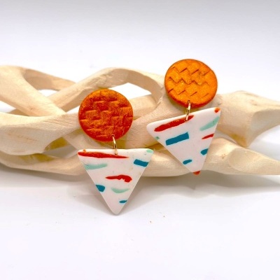 brincos pendentes redondos laranja e triangulares brancos com padrões coloridos