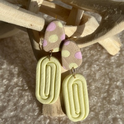 Brincos pendentes coloridos sobre madeira e tecido felpudo